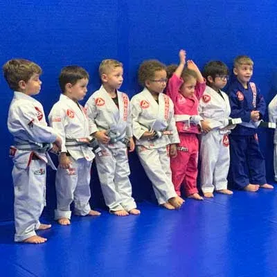 Une rangée de tout-petits en kimono blanc et rose, alignés sur le tatami