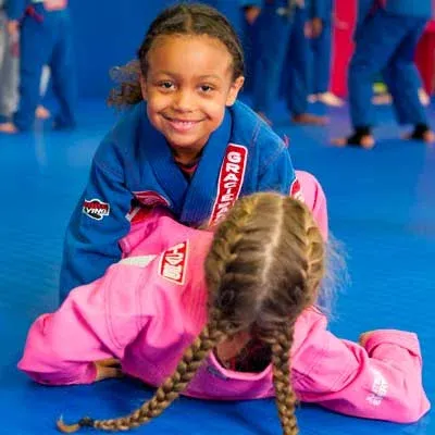 Une petite fille en kimono rose sourit allongée sur le tatami