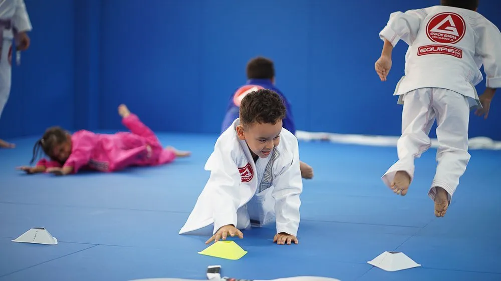 Cours enfants : les élèves ramassent des plots sur le tatami